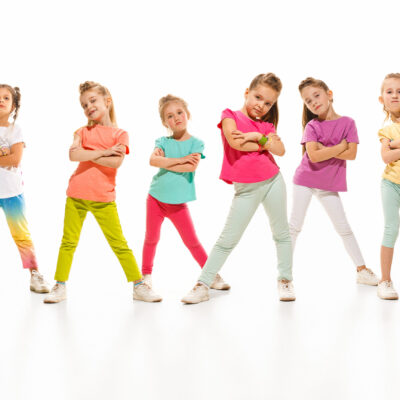 The kids dance school, ballet, hiphop, street, funky and modern dancers on white studio background. Girl is showing aerobic and dance element. Teen in hip hop style